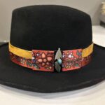 Ronald Joseph Kerr Black hat with ribbon, leather, and feather pendant
