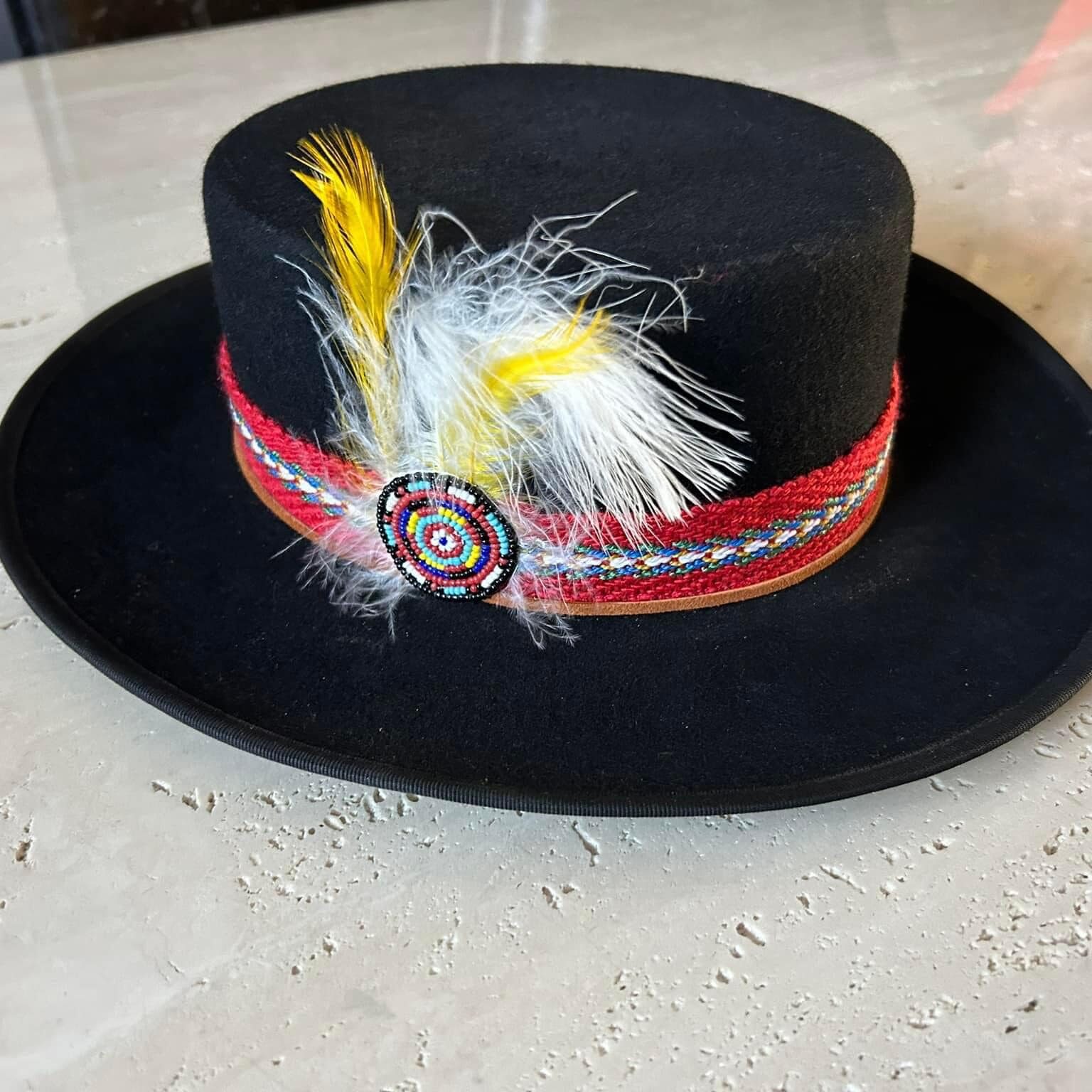 Ronald Joseph Kerr Black hat with ribbon, beadwork, and yellow/white feathers