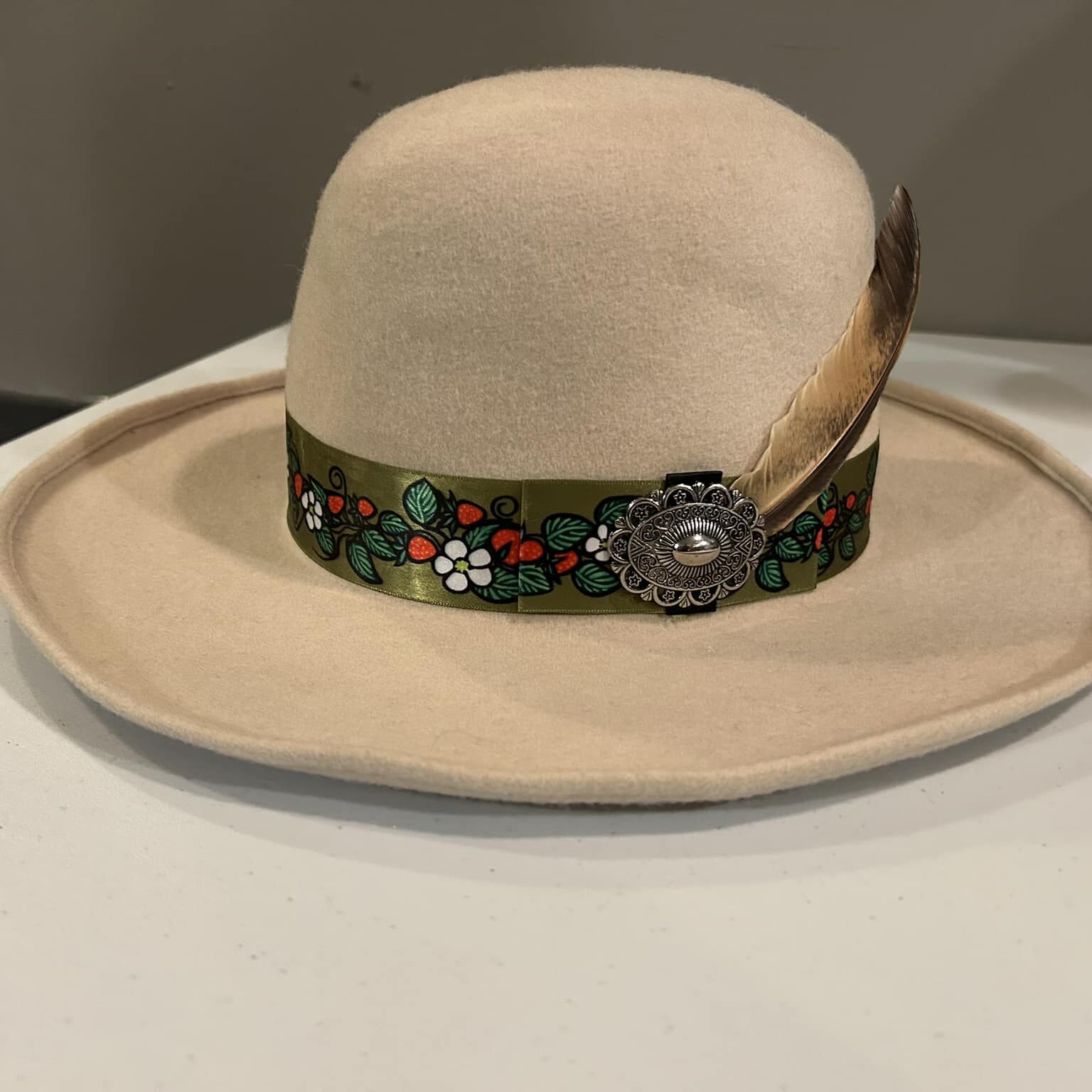 Ronald Joseph Kerr Side of beige hat with ribbon, feathers and pendant