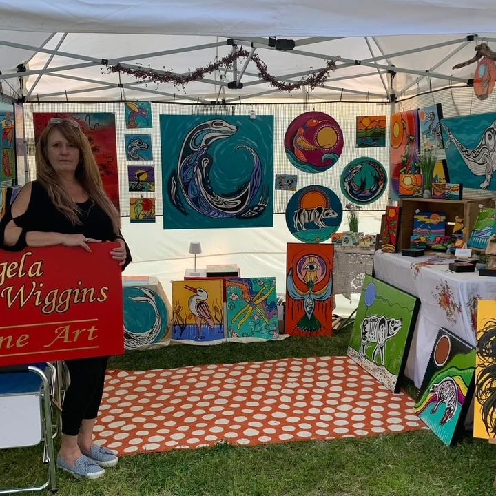 Angela-Wiggins-At vendor booth with paintings